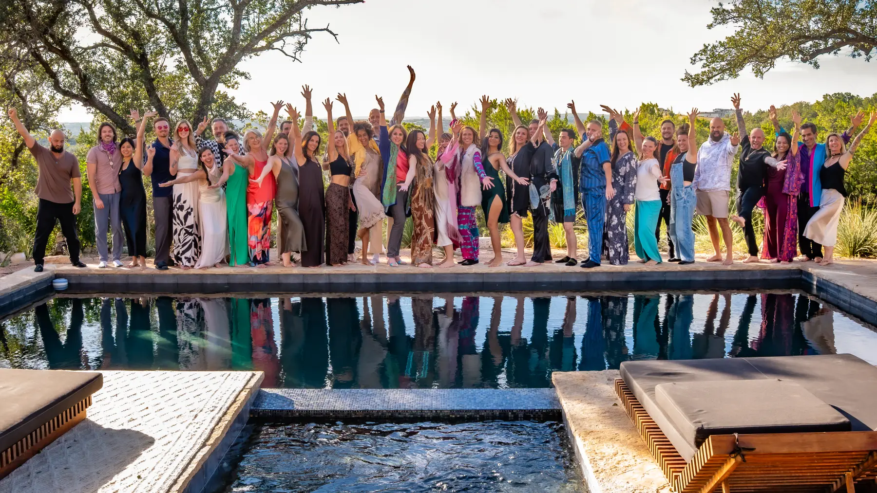 The Love Immersion VIII group with arms raised by the pool in the Texas Hill Country