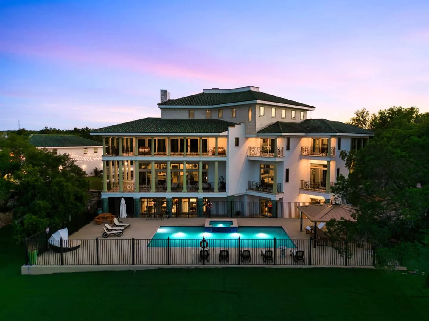 The pool and back of the mansion at twilight